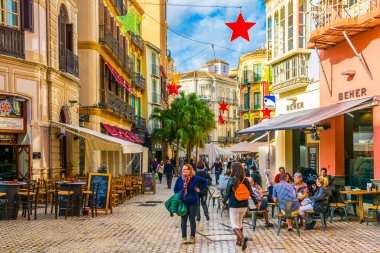 MALAGA, SPAIN, JANUARY 4, 2016: Malaga 'nın tarihi merkezinde turist kalabalığının restoran veya bar aradığı dar bir sokak manzarası.