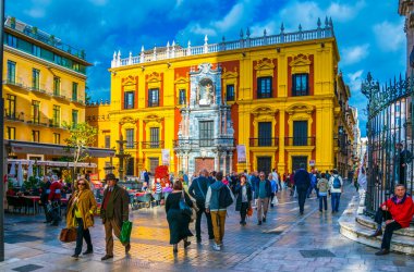 MALAGA, SPAIN, JANUARY 4, 2016: people are enjoying sunny day in january while sitting on a terrace of a cafe situated in front of the Episcopal palace on plaza del obispo in Malaga