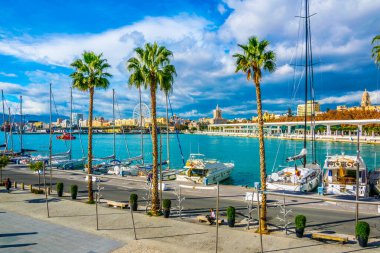 MALAGA, SPAIN, JANUARY 4, 2016: İspanya 'nın Malaga limanındaki marinayla çevrili bir gezinti alanında insanlar yürüyor.