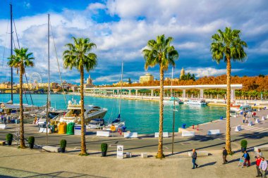 MALAGA, SPAIN, JANUARY 4, 2016: İspanya 'nın Malaga limanındaki marinayla çevrili bir gezinti alanında insanlar yürüyor.