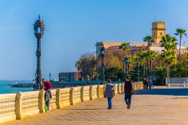 CADIZ, SPAIN, JANUARY 6, 2016: people are walking on a seaside promenade in cadiz