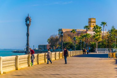 CADIZ, SPAIN, JANUARY 6, 2016: people are walking on a seaside promenade in cadiz