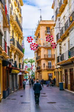 CADIZ, SPAIN, JANUARY 6, 2016: people are stolling through a narrow street in historical center of spanish city cadiz