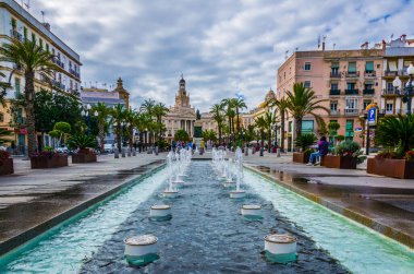 CADIZ, SPAIN, JANUARY 6, 2016: View of a fountain situated on the square of saint john of god in cadiz with town hall on background