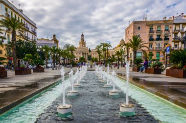 CADIZ, SPAIN, HAZİRAN 6 HAZİRAN 2016: Cadiz 'de Aziz John Meydanı' nda arka planda belediye binası bulunan bir çeşmenin manzarası