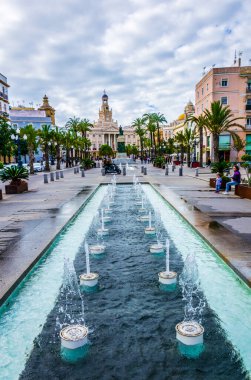 CADIZ, SPAIN, HAZİRAN 6 HAZİRAN 2016: Cadiz 'de Aziz John Meydanı' nda arka planda belediye binası bulunan bir çeşmenin manzarası