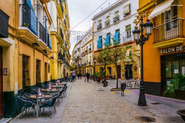 CADIZ, SPAIN, JANUARY 6, 2016: people are stolling through a narrow street in historical center of spanish city cadiz