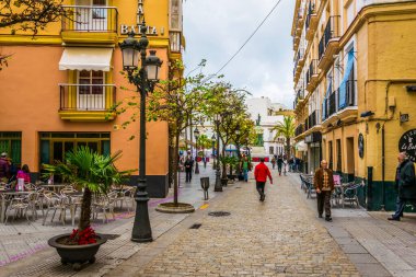 CADIZ, SPAIN, HAZİRAN 6 HAZİRAN 2016: İspanya 'nın tarihi Cadiz kentinde insanlar dar bir caddede çalıyorlar