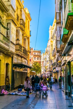 CADIZ, SPAIN, HAZİRAN 6 HAZİRAN 2016: İspanya 'nın tarihi Cadiz kentinde insanlar dar bir caddede çalıyorlar
