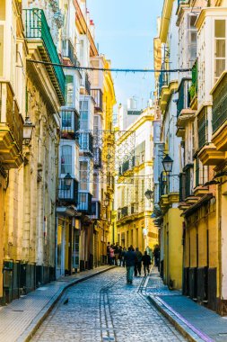 CADIZ, SPAIN, HAZİRAN 6 HAZİRAN 2016: İspanya 'nın tarihi Cadiz kentinde insanlar dar bir caddede çalıyorlar