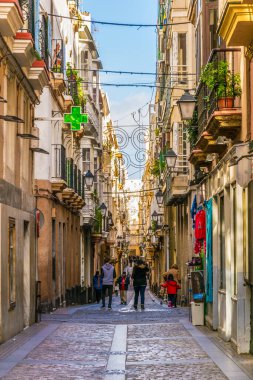 CADIZ, SPAIN, JANUARY 6, 2016: people are stolling through a narrow street in historical center of spanish city cadiz