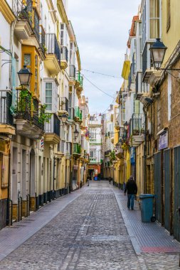 CADIZ, SPAIN, HAZİRAN 6 HAZİRAN 2016: İspanya 'nın tarihi Cadiz kentinde insanlar dar bir caddede çalıyorlar