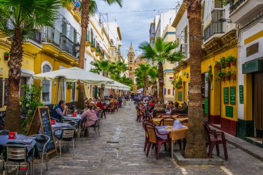 CADIZ, SPAIN, HAZİRAN 6 HAZİRAN: İspanya 'nın Cadiz kentindeki Calle de la Virgen' de insanlar öğle yemeğinin tadını çıkarıyorlar