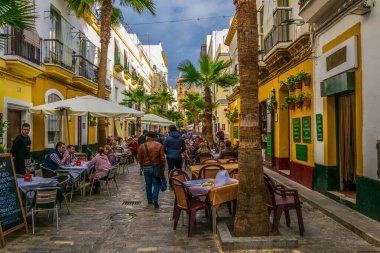 CADIZ, SPAIN, HAZİRAN 6 HAZİRAN: İspanya 'nın Cadiz kentindeki Calle de la Virgen' de insanlar öğle yemeğinin tadını çıkarıyorlar