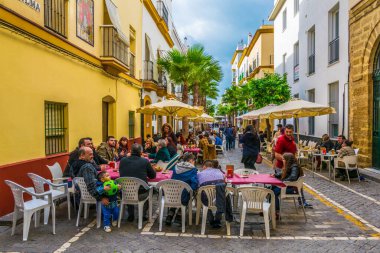 CADIZ, SPAIN, HAZİRAN 6 HAZİRAN: İspanya 'nın Cadiz kentindeki Calle de la Virgen' de insanlar öğle yemeğinin tadını çıkarıyorlar
