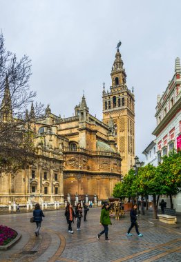 SEVILLA, SPAIN, JANUARY 7, 2016: İspanya 'nın Sevilla kentindeki la giralda kulesinin altından bir grup turist geçiyor