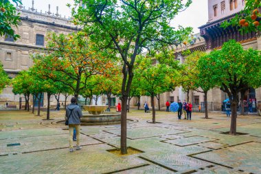 SEVILLA, SPAIN, JANUARY 7, 2016: İspanya 'nın Sevilla kentindeki katedralin içindeki Los Naranjos terasından insanlar çalıyor