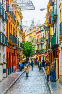 SEVILLA, SPAIN, JANUARY 7, 2016: İspanya 'nın merkezindeki dar bir caddede insanlar çalınıyor