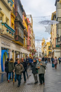 SEVILLA, SPAIN, JANUARY 7, 2016: İspanya 'nın merkezindeki dar bir caddede insanlar çalınıyor