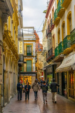 SEVILLA, SPAIN, JANUARY 7, 2016: İspanya 'nın merkezindeki dar bir caddede insanlar çalınıyor