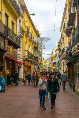 SEVILLA, SPAIN, JANUARY 7, 2016: people are stolling through a narrow street situated in the center of the spanish city sevilla