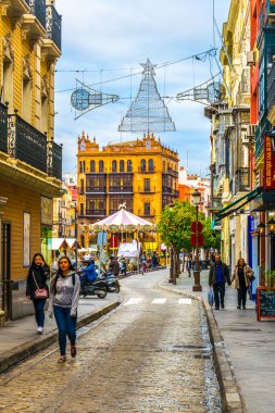 SEVILLA, SPAIN, JANUARY 7, 2016: people are stolling through a narrow street situated in the center of the spanish city sevilla