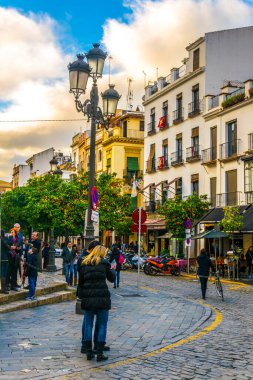 SEVILLA, SPAIN, JANUARY 7, 2016: İspanya 'nın merkezindeki dar bir caddede insanlar çalınıyor