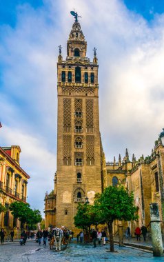 SEVILLA, SPAIN, JANUARY 7, 2016: İspanya 'nın Sevilla kentindeki la giralda kulesinin önünde insanlar geziniyor
