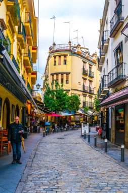 SEVILLA, SPAIN, JANUARY 7, 2016: İspanya 'nın merkezindeki dar bir caddede insanlar çalınıyor