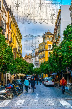 SEVILLA, SPAIN, JANUARY 7, 2016: İspanya 'nın merkezindeki dar bir caddede insanlar çalınıyor