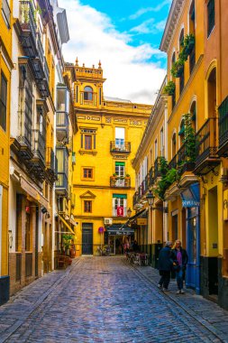 SEVILLA, SPAIN, JANUARY 7, 2016: İspanya 'nın merkezindeki dar bir caddede insanlar çalınıyor