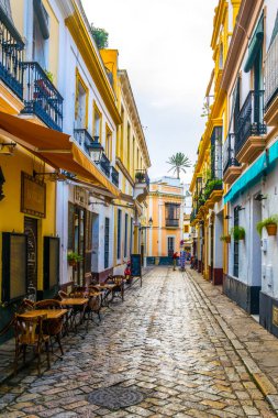 SEVILLA, SPAIN, JANUARY 7, 2016: people are stolling through a narrow street situated in the center of the spanish city sevilla