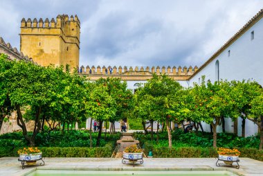 CORDOBA, SPAIN, JANUARY 8, 2016: people are strolling through an inner courtayrd of the alcazar de los reyes cristianos - royal palace of the cristian kings in the spanish city cordoba