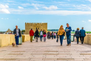 CORDOBA, SPAIN, HAZİRAN 8 HAZİRAN 2016: İspanya 'nın Cordoba kentindeki Roma köprüsünden geçerek La mezquita katedraline doğru yürüyorlar.