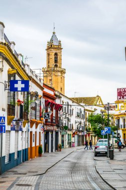 CORDOBA, SPAIN, JANUARY 8, 2016: people are strolling through calle san pablo street with building of the church of apostle san andres at far end.