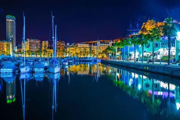 ALICANTE, SPAIN, 2 HAZİRAN 2016: İspanya 'nın Alicante kentindeki aydınlık rıhtımın gece manzarası, bir taraftan marina, diğer taraftan restoran ve barların kemeri ile çevrili.