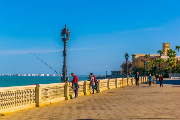 CADIZ, SPAIN, JANUARY 6, 2016: people are walking on a seaside promenade in cadiz