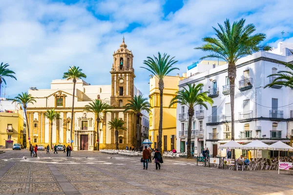 CADIZ, SPAIN, JANUARY 6, 2016: İspanya 'nın Cadiz kentindeki Santiago Kilisesi önünde insanlar plaza de la kategorisinden geçiyorlar