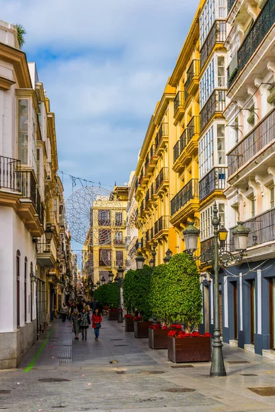 CADIZ, SPAIN, JANUARY 6, 2016: people are stolling through a narrow street in historical center of spanish city cadiz