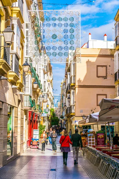 CADIZ, SPAIN, HAZİRAN 6 HAZİRAN 2016: İspanya 'nın tarihi Cadiz kentinde insanlar dar bir caddede çalıyorlar