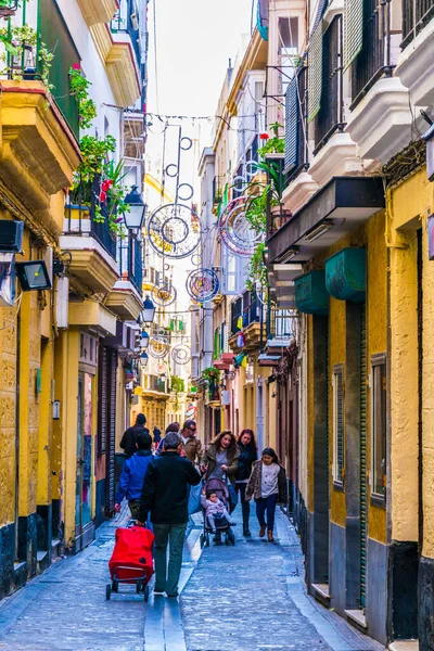 CADIZ, SPAIN, HAZİRAN 6 HAZİRAN 2016: İspanya 'nın tarihi Cadiz kentinde insanlar dar bir caddede çalıyorlar