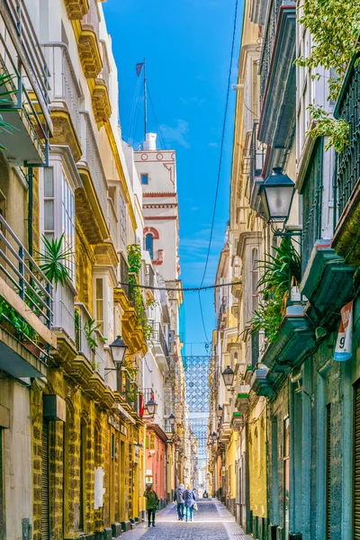 CADIZ, SPAIN, HAZİRAN 6 HAZİRAN 2016: İspanya 'nın tarihi Cadiz kentinde insanlar dar bir caddede çalıyorlar