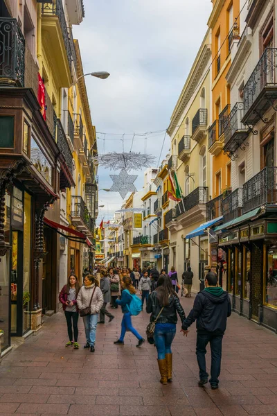 SEVILLA, SPAIN, JANUARY 7, 2016: İspanya 'nın merkezindeki dar bir caddede insanlar çalınıyor