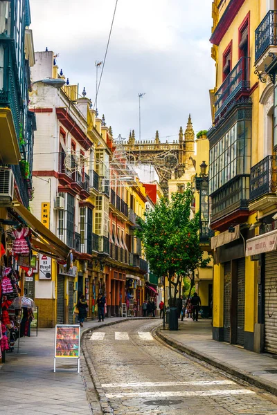 SEVILLA, SPAIN, JANUARY 7, 2016: İspanya 'nın merkezindeki dar bir caddede insanlar çalınıyor