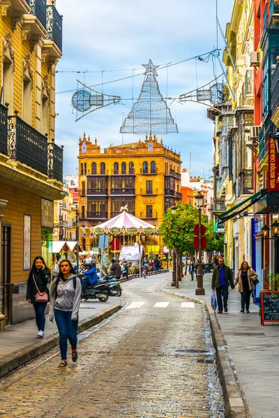SEVILLA, SPAIN, JANUARY 7, 2016: İspanya 'nın merkezindeki dar bir caddede insanlar çalınıyor