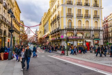 MADRID, SPAIN, HAZİRAN 9 HAZİRAN: İspanya 'nın başkenti Madrid' deki Puerta del Sol Meydanı 'na giden dar bir sokakta insanlar yürüyor