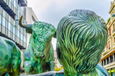 PAMPLONA, SPAIN, ECTOBER 28, 2014: İspanya 'nın Pamplona kentindeki boğaların önünde koşan insanları resmeden Encierro heykeli