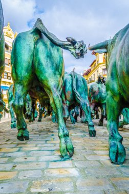 PAMPLONA, SPAIN, ECTOBER 28, 2014: İspanya 'nın Pamplona kentindeki boğaların önünde koşan insanları resmeden Encierro heykeli