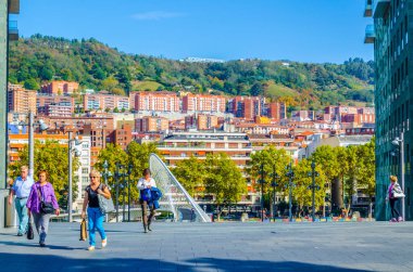 BILBAO, SPAIN, ECTOBER 29 Ekim 2014: İspanya 'nın Bilbao kentindeki Zubizuri Köprüsü' nden insanlar geçiyor