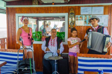 BURGAS, BULGARIA, 17 Temmuz 2015: Bir grup çingene müzisyen Burgaz yakınlarındaki Saint Anastasia adasına giden feribot yolcularını eğlendiriyor.